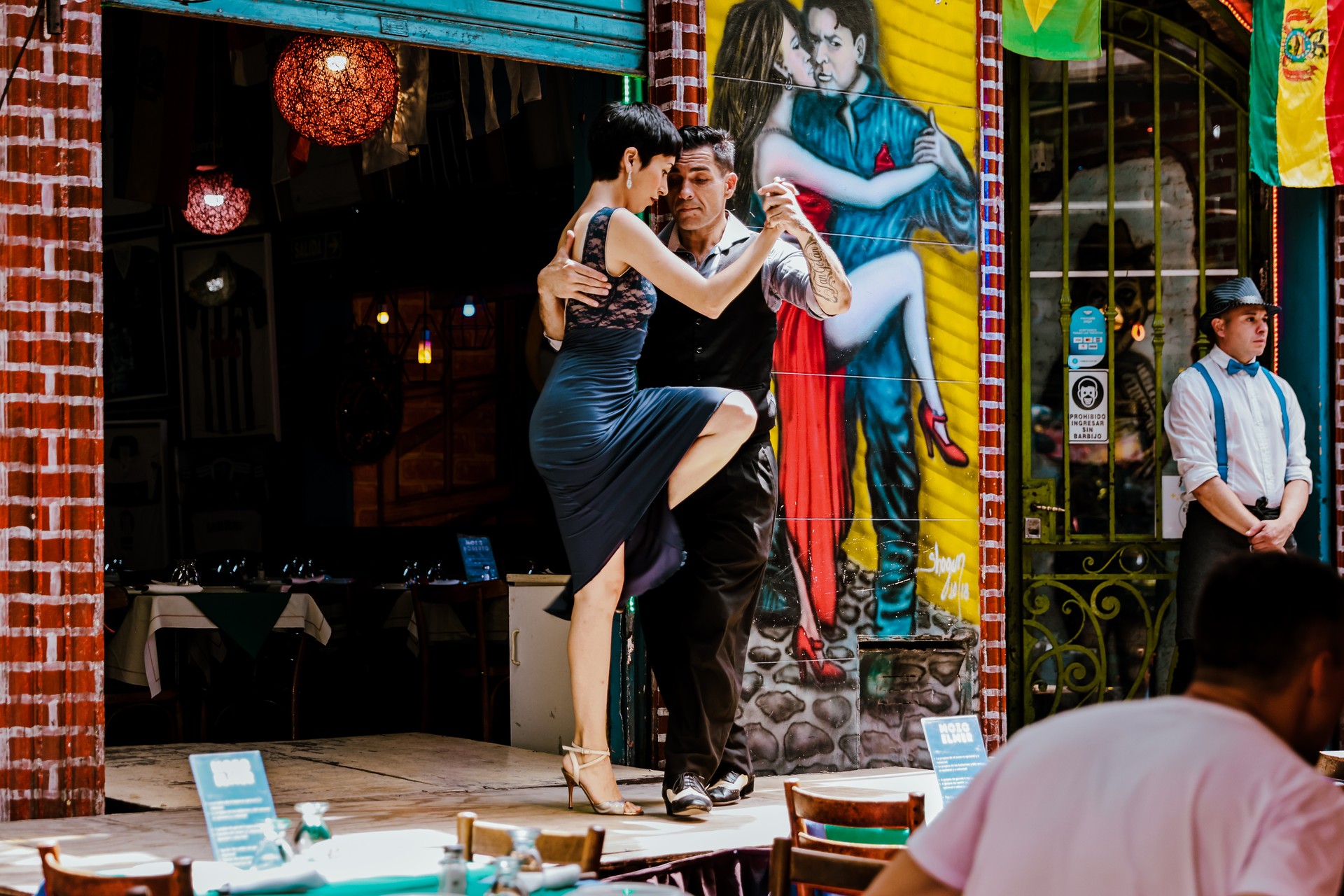 Tango dancers performing at a restaurant stage along streets of the Caminito district in Buenos Aires Argentina